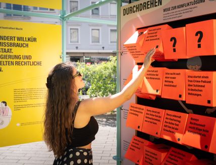 Ein Frau dreht an einem Würfelspiel der Ausstellung