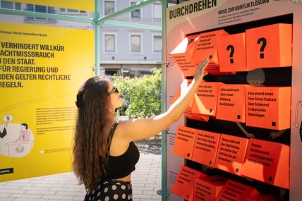 Ein Frau dreht an einem Würfelspiel der Ausstellung